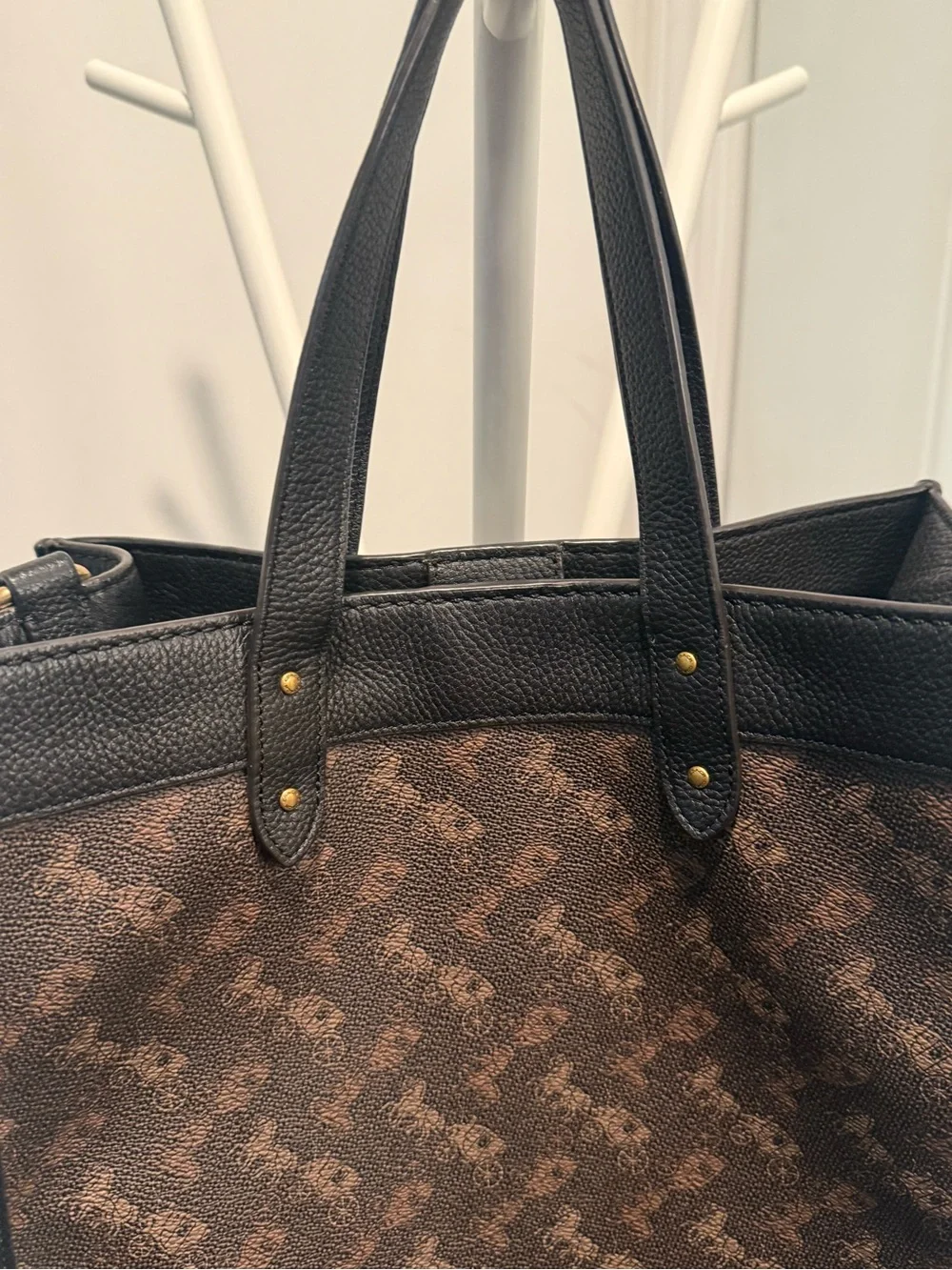 This is a Coach Field Tote in Truffle Black with a horse and carriage print